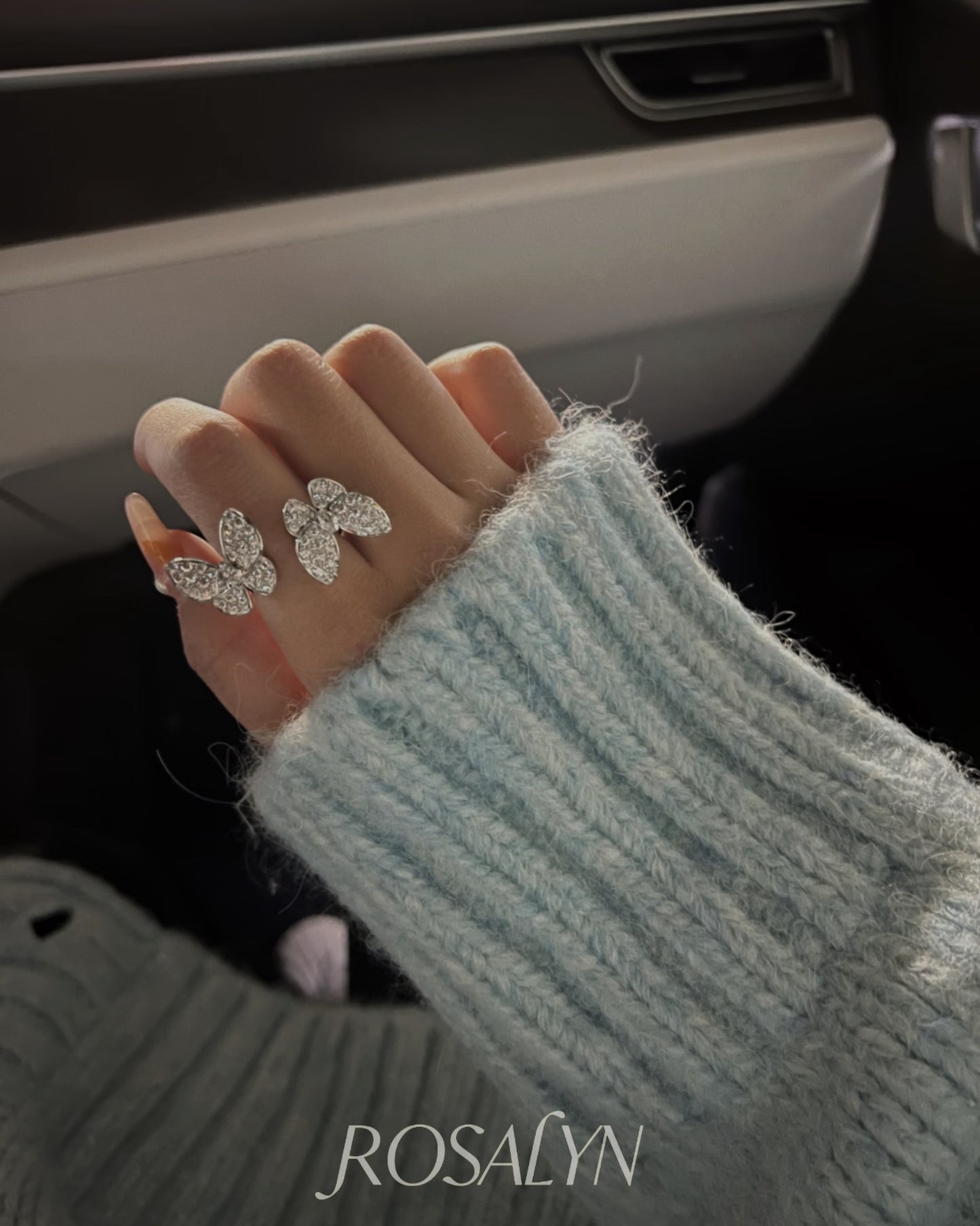 BUTTERFLY RING BETWEEN FINGERS